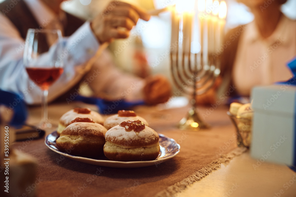 Naklejka premium Jewish traditional sufganiyah donuts with couple in background.