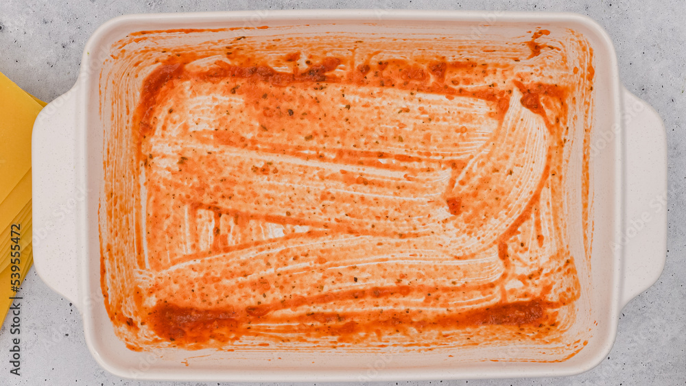 Baking dish with marinara sauce. Spinach lasagna step by step recipe Baking dish with marinara sauce. Spinach lasagna step by step recipe