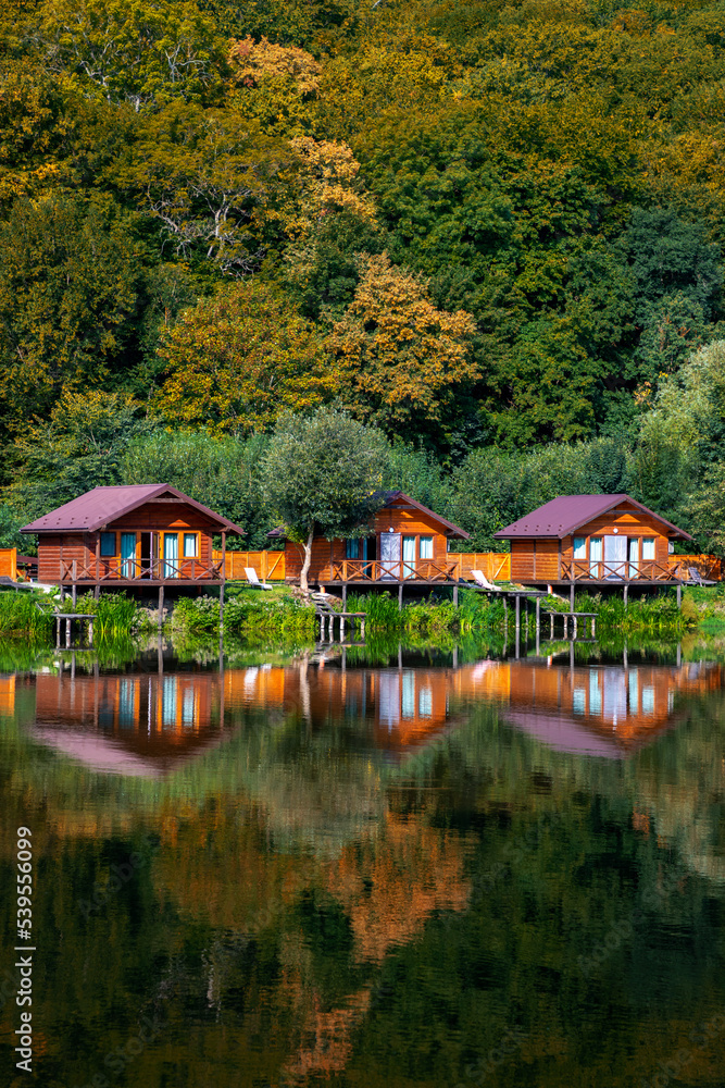 Wooden houses on the water near the forest for carp fishing. A place to relax in nature. Autumn carp fishing season. Wooden houses on the water near the forest for carp fishing. A place to relax in nature. Autumn carp fishing season.