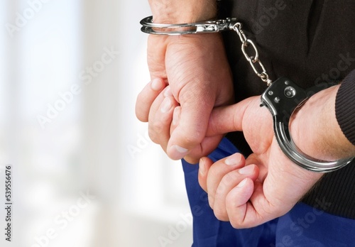 Human hands locked in handcuffs, crime concept