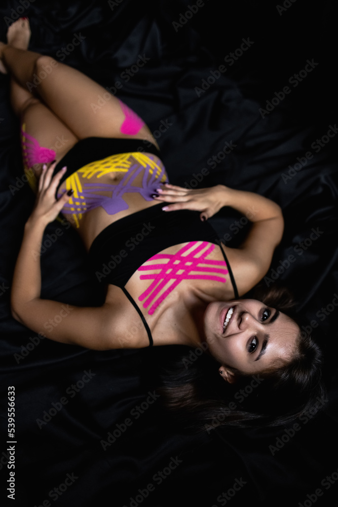 Fototapeta premium Cosmetology kinesio tapes on young woman waist and chest. Body care modern treatment for tighten skin muscle tissue and improve blood circulation. Anti-cellulite. Sport. Beautiful body. Fit. Care.