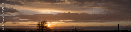 Landscape at sunset. Tragic gloomy sky. Panorama. Crimson twilight.