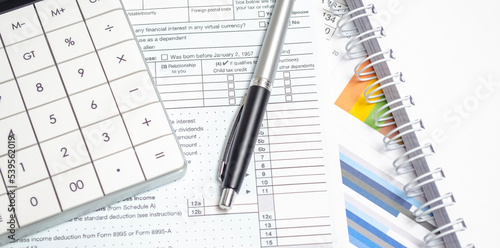US Individual Tax Return Form 1040 with calculator, pen and charts