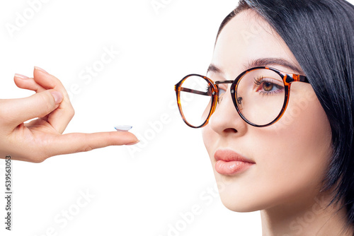 Young woman in glasses decides to wear contact lenses.