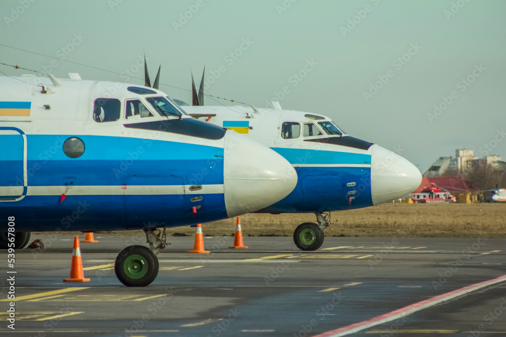Obraz premium Propeller-driven Soviet aircraft stand close-up in the parking lot at the airport against the backdrop of a clear sky.