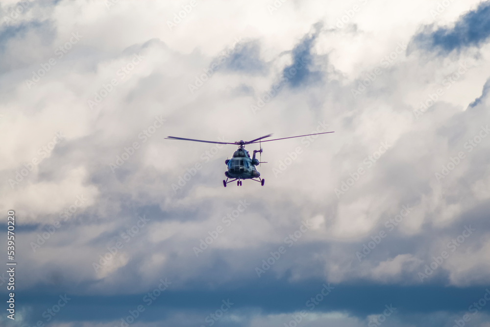 A military helicopter flies against the background of an overcast sky and against the background of heapy clouds, front view
A military helicopter flies against the background of an overcast sky and against the background of heapy clouds, front view