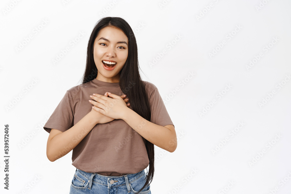 Beautiful korean girl looking with flattered, delighted face, pleased by smth, gazing at smth cute, white background Beautiful korean girl looking with flattered, delighted face, pleased by smth, gazing at smth cute, white background