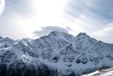 View of the mountain range, steep slopes and snow-capped rocky peaks. Selective focus.