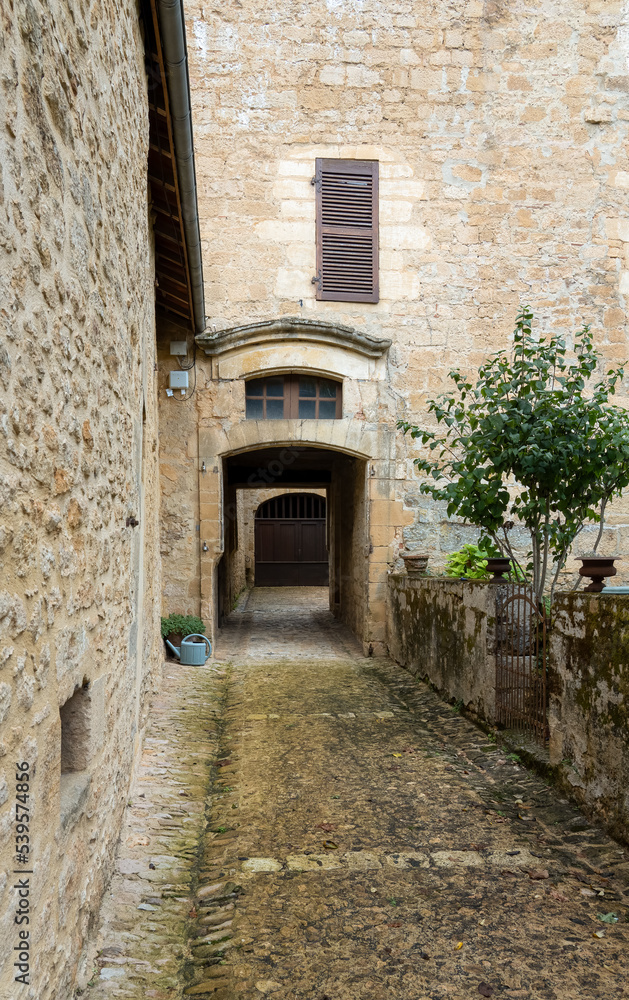 view up a narrow street between buildings of a beautifully preserved 14th century medieval town