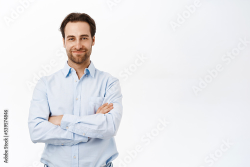 Handsome businessman standing in power pose, cross arms on chest, looking confident and professional, standing over white background