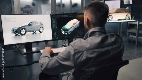 Two male automotive designers working on model of eco friendly electric car in modern car design studio. One working in 3D modeling computer software, other sculpting with plasticine clay and rake.