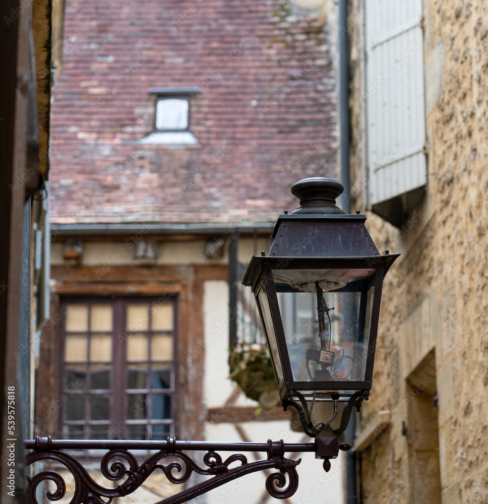 old black cast iron street lamps fitted with modern LED bulbs in a medieval town