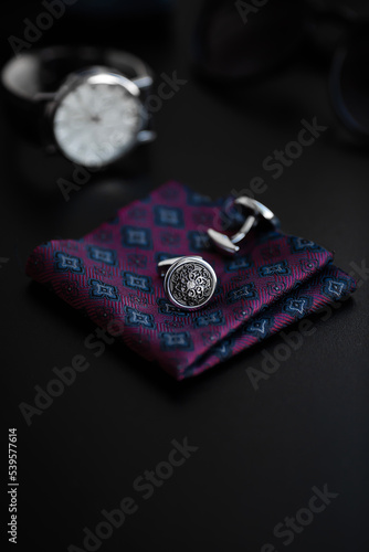 Business accessories. Luxury Men's cufflinks with watch, breastplate and sunglasses close up.