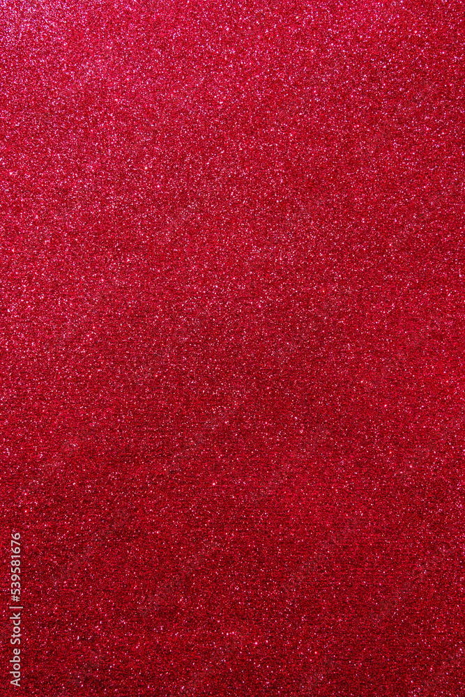 Background with sparkles. Backdrop with glitter. Shiny textured surface. Vertical image. Dark red