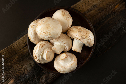 Mushrooms in a plate on a wooden table.