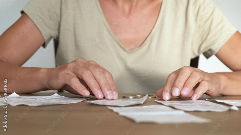 Count natural gas bills. A woman count her last money by the electricity bills on the table. A concept of family poverty and financial crisis in the world. Count natural gas bills. A woman count her last money by the electricity bills on the table. A concept of family poverty and financial crisis in the world.