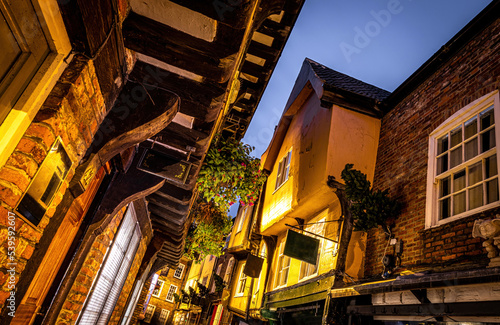 A Chirstmas night view of Shambles, a historic street in York featuring preserved medieval timber-framed buildings with jettied floors