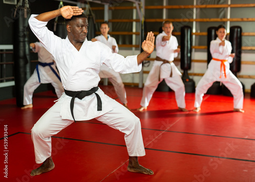African american man in kimono fighting stance at karate training