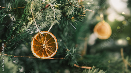 Foto Rustic decorated ornament on Christmas tree with dried orange slices, sustainabl