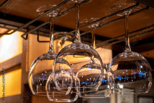 Close up view of wine glasses hanging above a bar counter at a restaurant
