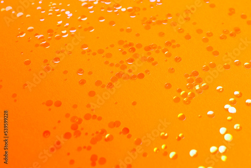 Shiny bright glitter scattered on orange background