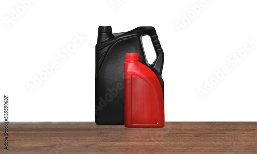 Motor oil in different containers on wooden table against white background
