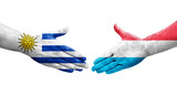 Handshake between Luxembourg and Uruguay flags painted on hands, isolated transparent image.