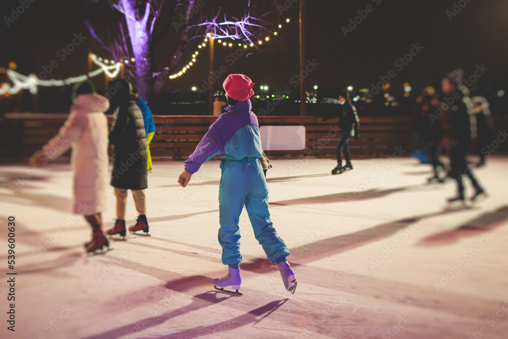 Foto Stock Girl ice skating on the ice rink arena with happy people