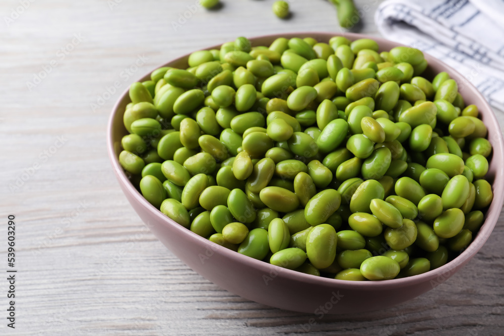 Bowl of delicious edamame beans on light wooden table, closeup Bowl of delicious edamame beans on light wooden table, closeup
