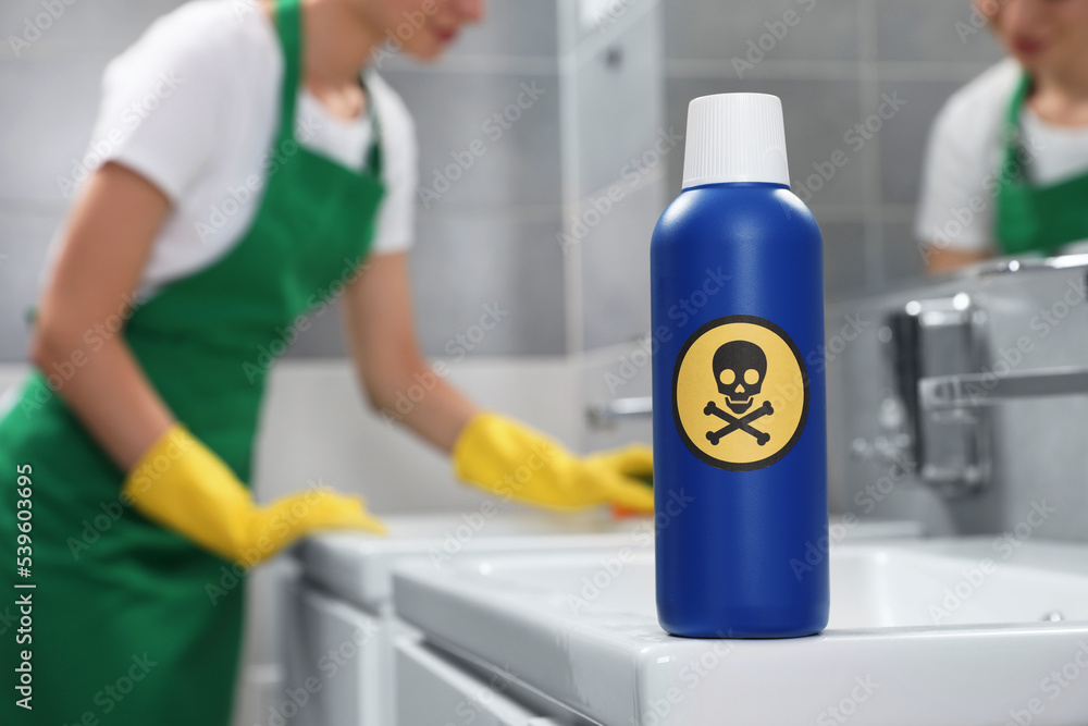 Bottle of toxic household chemical with warning sign in bathroom Bottle of toxic household chemical with warning sign in bathroom