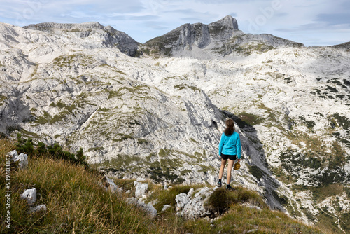 Woman Hiker Looking at View of Julian Alps with Mount Krn from Top of Mount Smohor above Krn Lake - Slovenia Europe