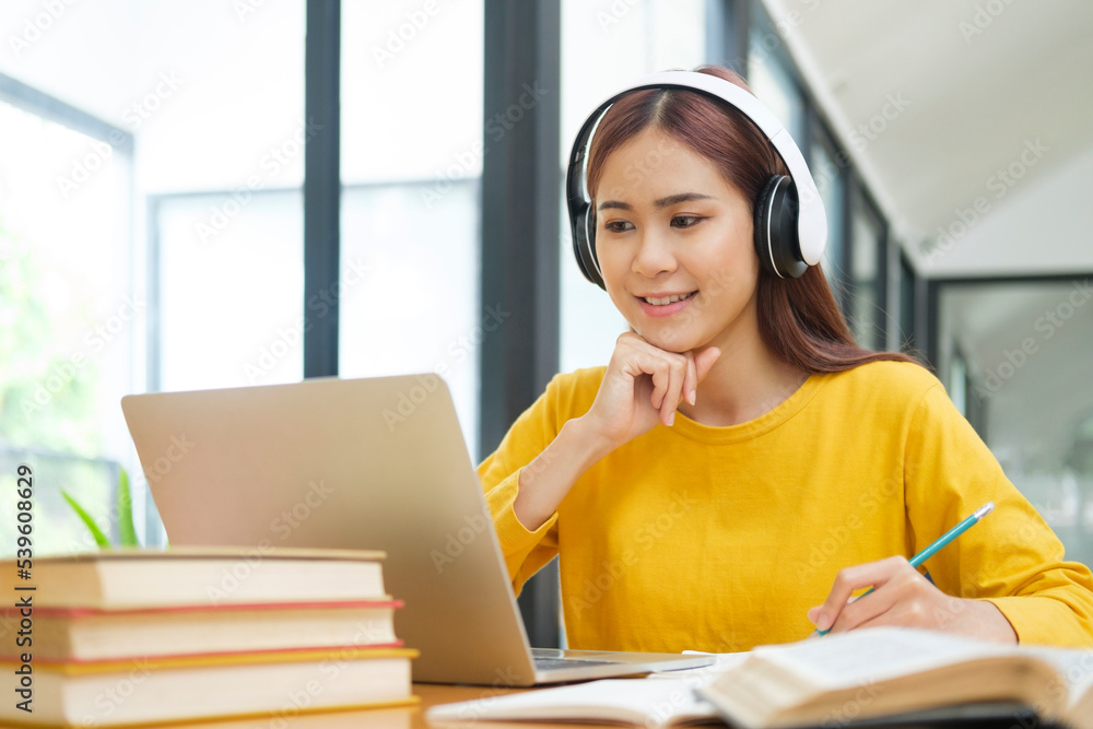 Woman learning online using laptop and writing notes. Woman learning online using laptop and writing notes.