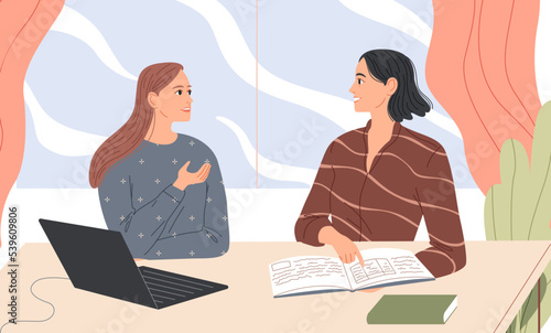 Two women sit at the desk and talk.
