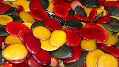 Sliced, polished tagua nuts, dyed warm colors, at a tagua nut jewelry shop in Iluman, Ecuador photo