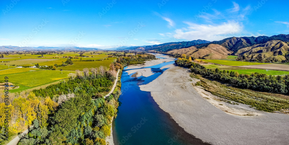 An aerial view of a beautiful river with a broad riverbank and a mountain range in the background on the South Island of New Zealand An aerial view of a beautiful river with a broad riverbank and a mountain range in the background on the South Island of New Zealand