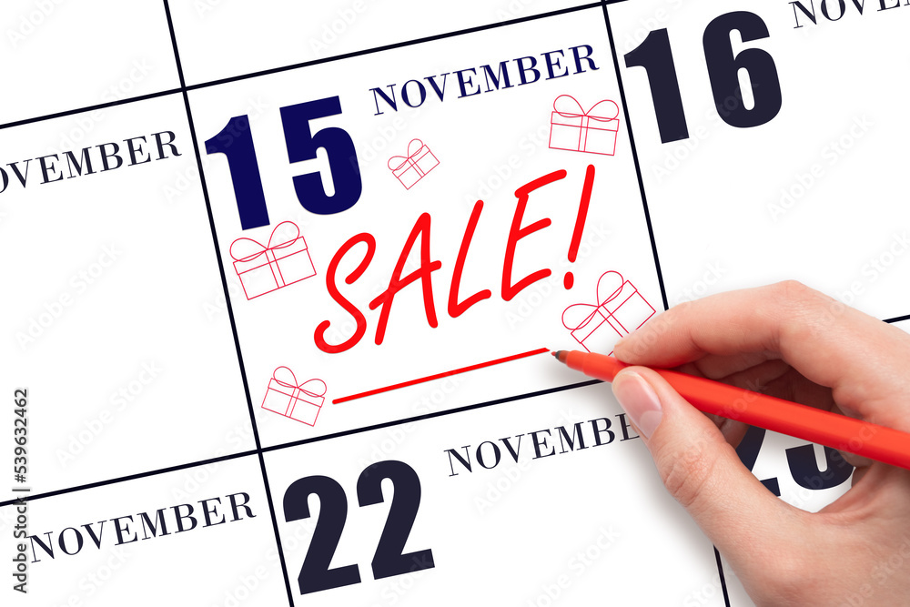 Hand writing text SALE and drawing gift boxes on calendar date November 15. Shopping Reminder Hand writing text SALE and drawing gift boxes on calendar date November 15. Shopping Reminder