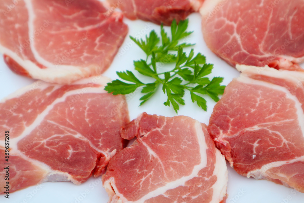 Raw Pork Slice in White Round Plate decorated with parsley. Fresh raw pork. Raw Pork Slice in White Round Plate decorated with parsley. Fresh raw pork.