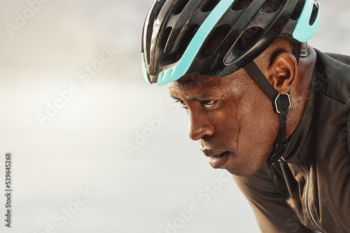 Cyclist man, sweating and focus for marathon race, competition or sports event on sky mock up for advertising space or marketing. Cycling sports person in helmet tired for training fitness challenge photo