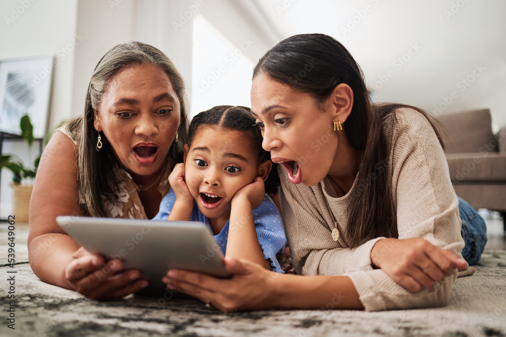 Fototapeta premium Digital tablet, family and wow in a living room with multigenerational women bonding on a floor, surprised, shock and excited. Relax, happy family and good news with mother, girl and grandma online