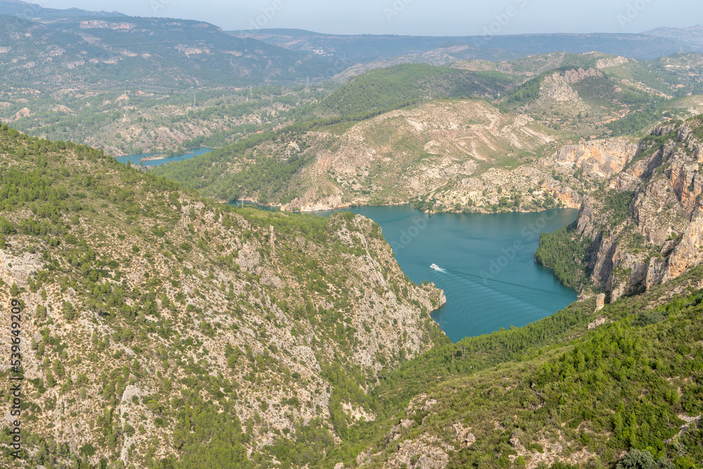 Beautiful landscape photo of the cortes del pallas reservoir with a boat on the water and the surroundings with nature, Valencian community, Spain