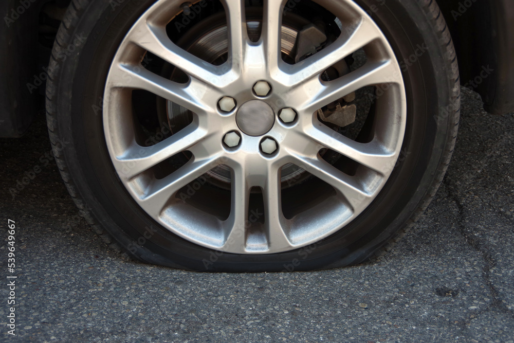 Flat tire on the rear wheel of a car