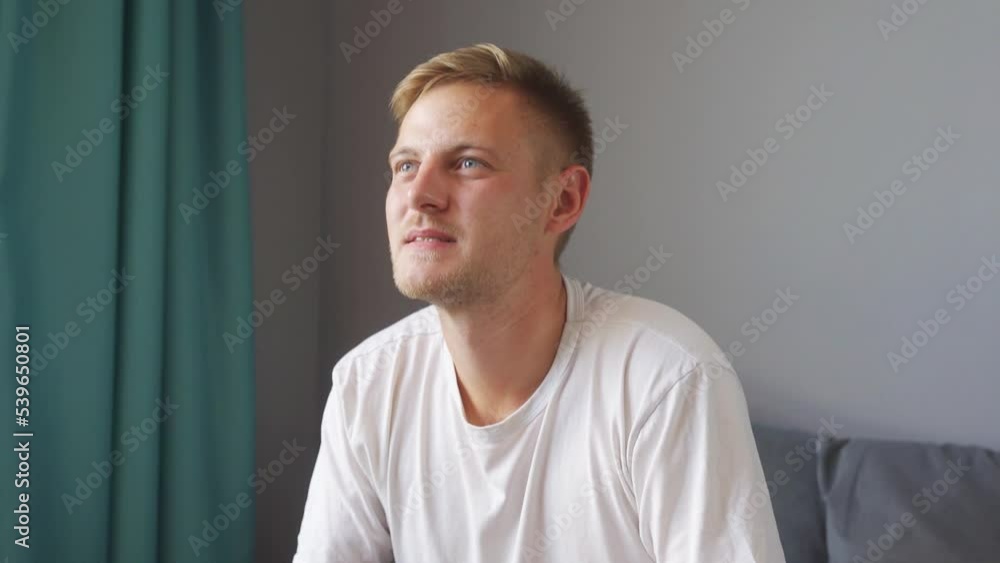 A man is playing a game at home. upset about losing