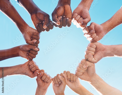 Photos Fist hands, circle and diversity support human rights people, protest group and freedom of racism on blue sky background
