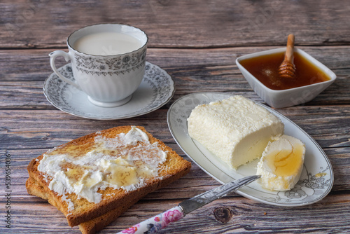Clotted cream (butter cream) for Turkish breakfast - Kaymak, honey and glass of milk photo