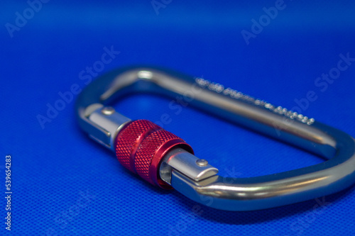 Carabiners for mountaineering and climbing on a blue background. Strong metal link for industry use