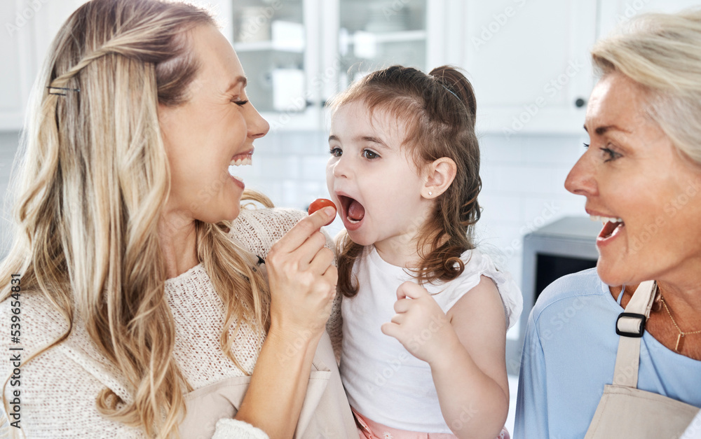 Family, feeding and tomato with a girl and mother eating together in their home while grandmother comes to visit. Food, children and vegetables with a woman giving a daughter something healthy to eat