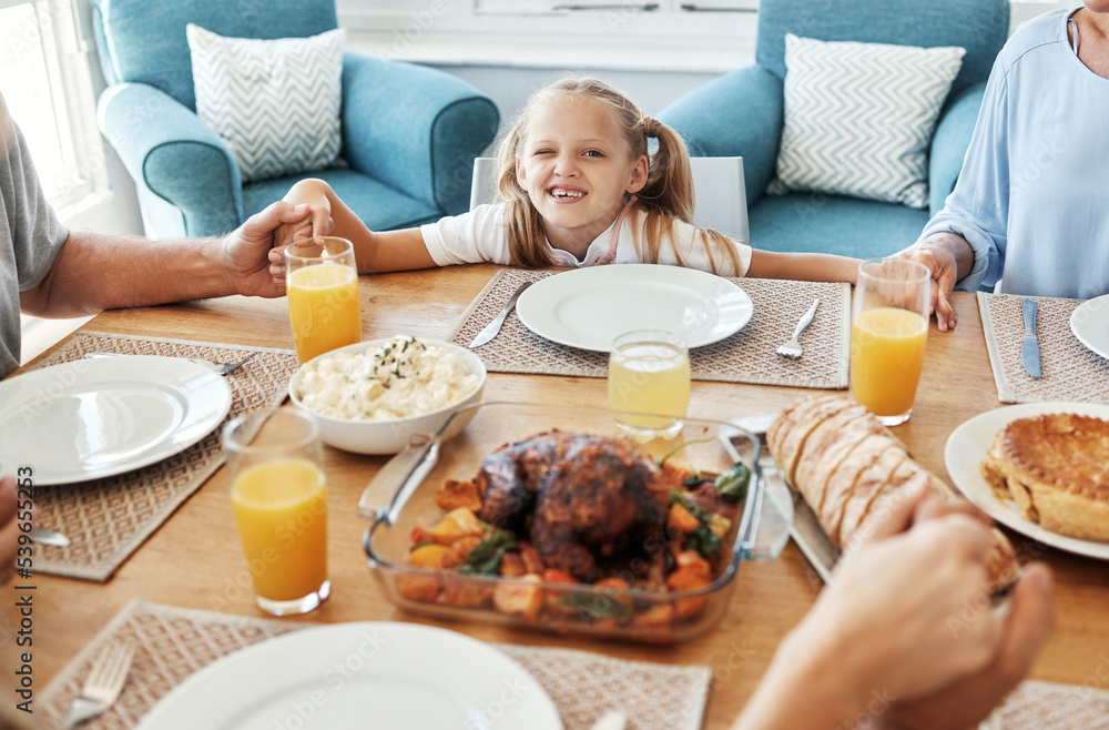 Food, family and praying with girl at a table, holding hands in gratitude, prayer and bonding before eating. Worship, pray time and child looking curious, hungry and playful while looking at a meal