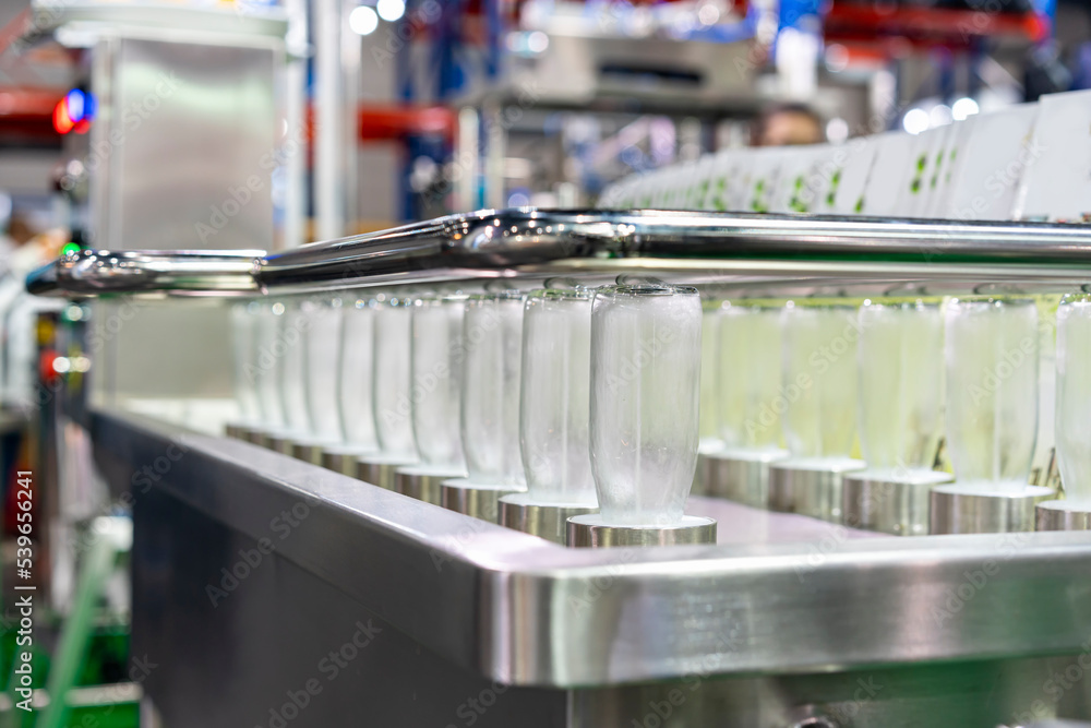 row glass bottle arrange on automatic bottle washer and sanitizing machine in beverage