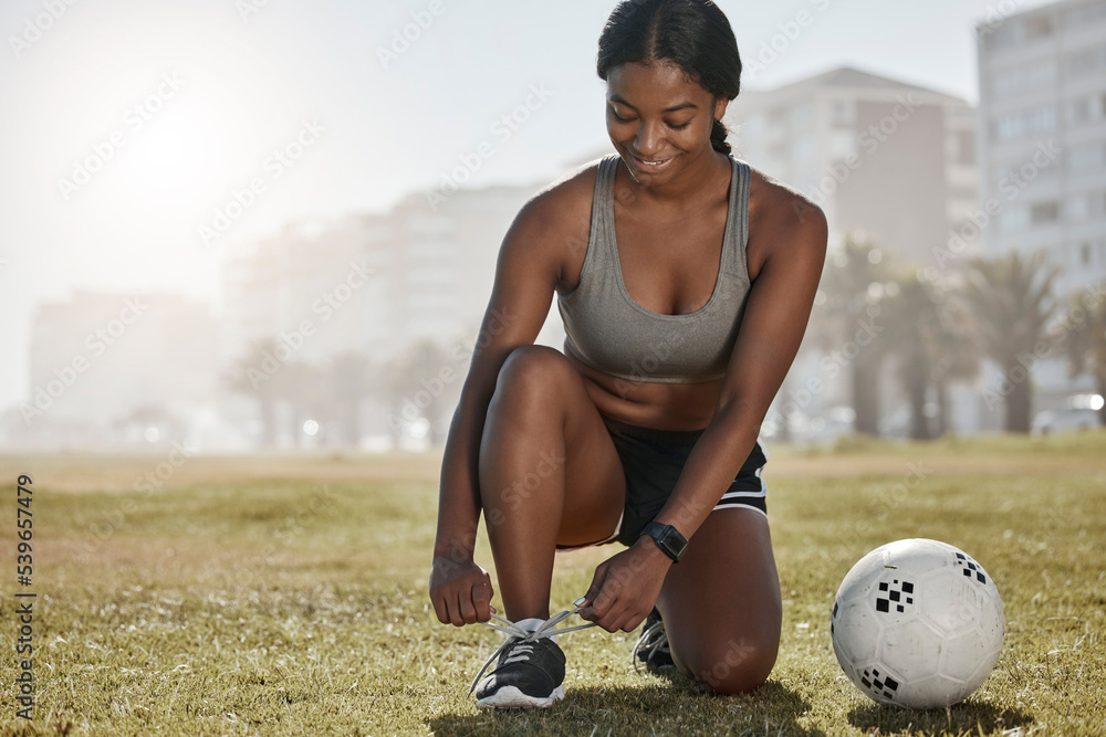Foto Stock Soccer, girl and black woman with shoes to start playing a  football game for cardio exercise, workout and training. Sports, fitness  and healthy athlete exercising ties boots on grass in