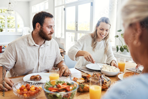 Food  family and couple eating at a table  happy  relax and bonding in their home together. Lunch  happy family and thanksgiving feast with cheerful people sharing a meal  fresh  cheerful and fun